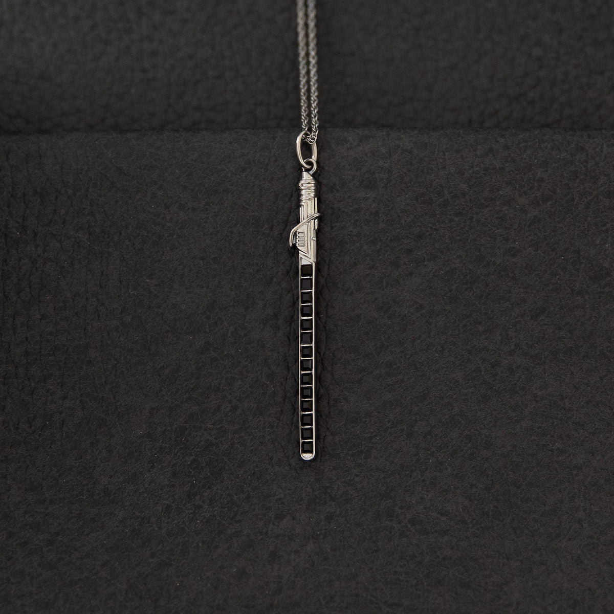 Detailed view of the sterling silver Darksaber necklace pendant with black energy blade design.