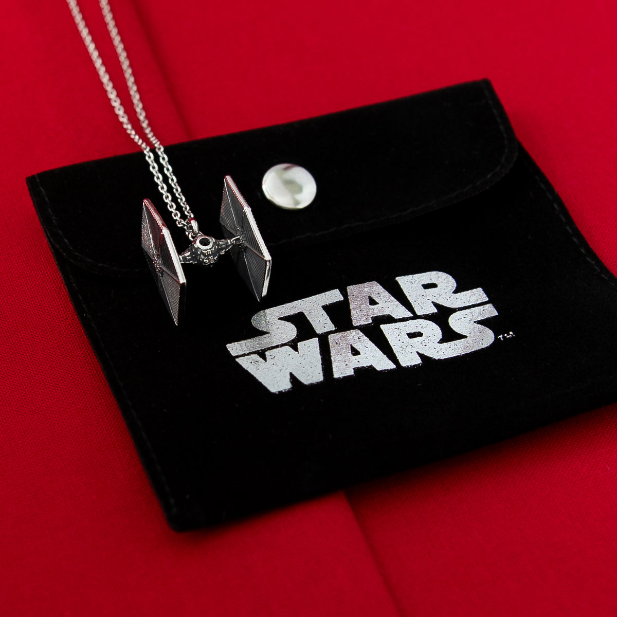 The Star Wars x RockLove TIE Fighter Necklace being worn for scale.